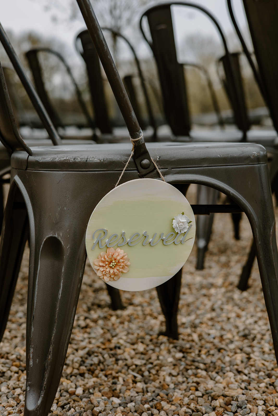 Rustic metal ceremony chairs with a reserved sign.