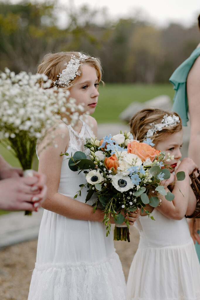 Flower girl holding the bride's bouquet during the ceremony.