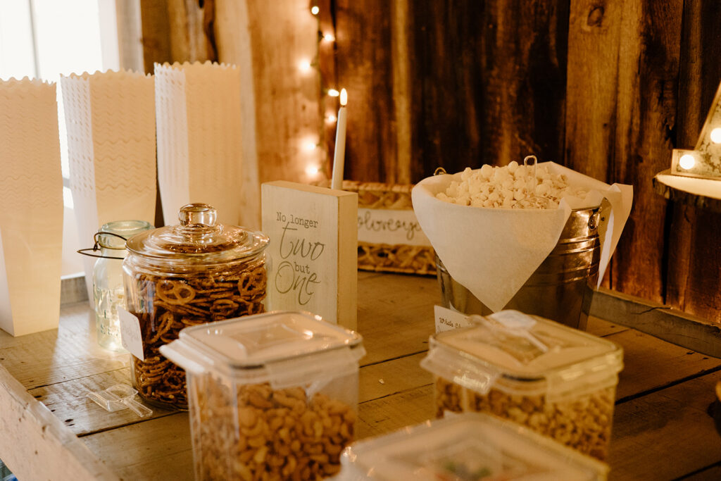 Rustic wedding treat table with popcorn, pretzels and desserts.