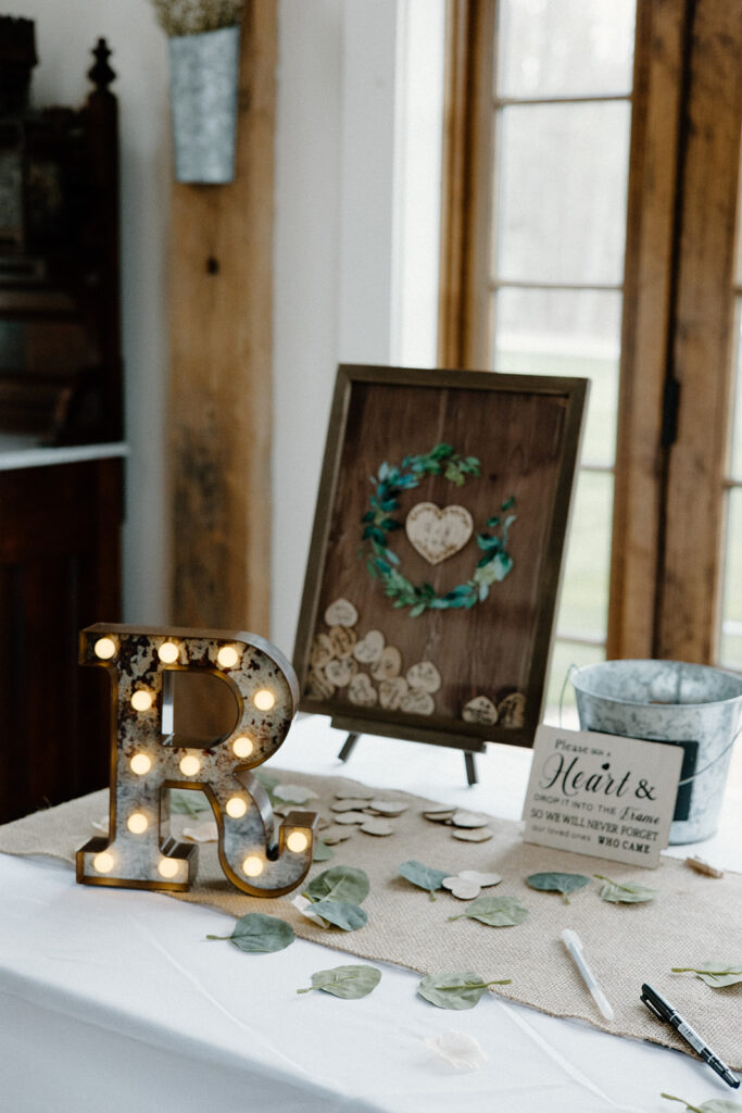 Rustic wedding welcome table with wooden heart shadow box.