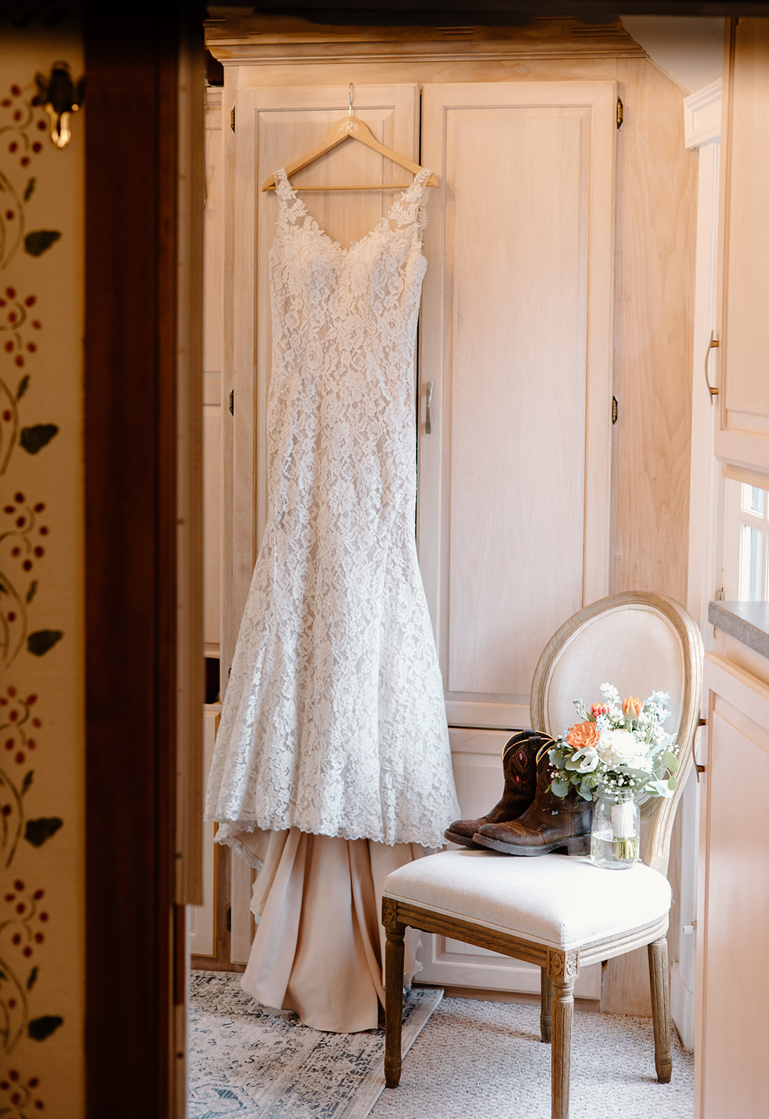 Rustic wedding dress hanging on a natural wood wardrobe.