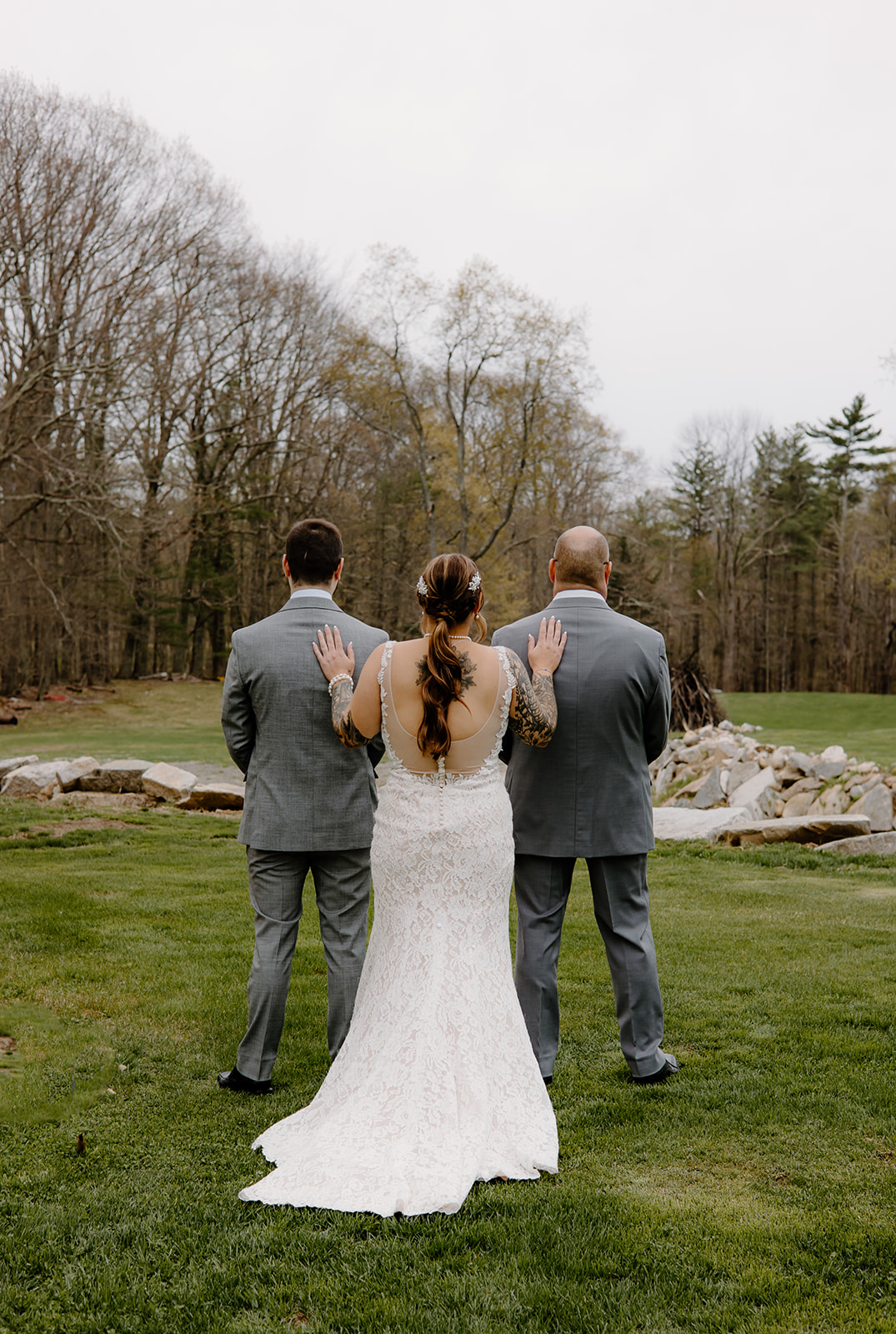 Bride touching the shoulders of her dad and brother for an emotional pre-ceremony first look.