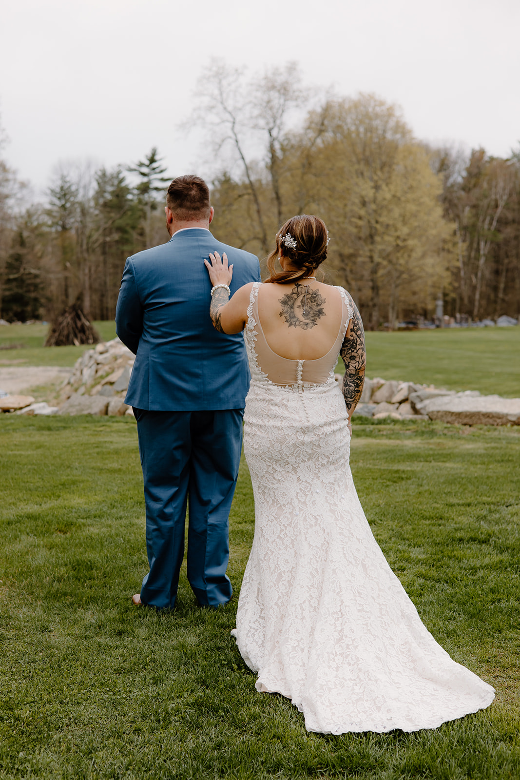 Bride touching groom's shoulder for their first look.
