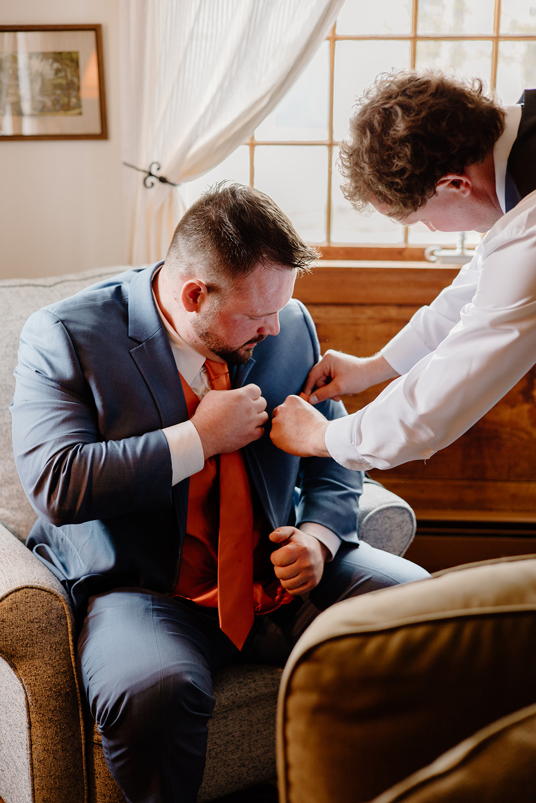 Groomsmen helping groom with pocket square.