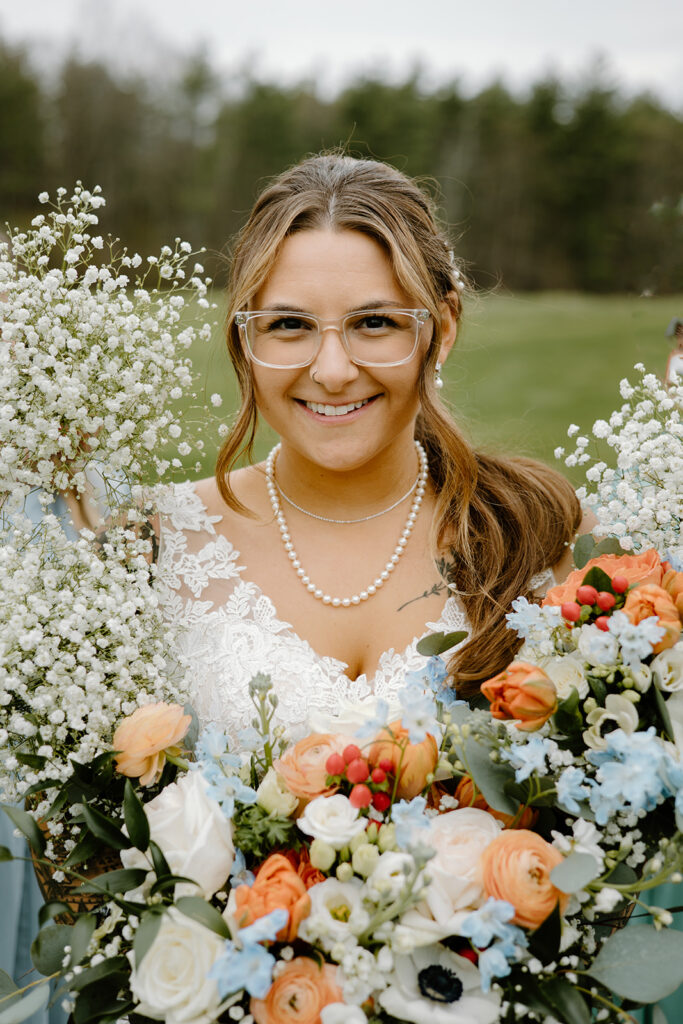 Bride holding her wedding bouquet and bridesmaids framing her with their bouquets.