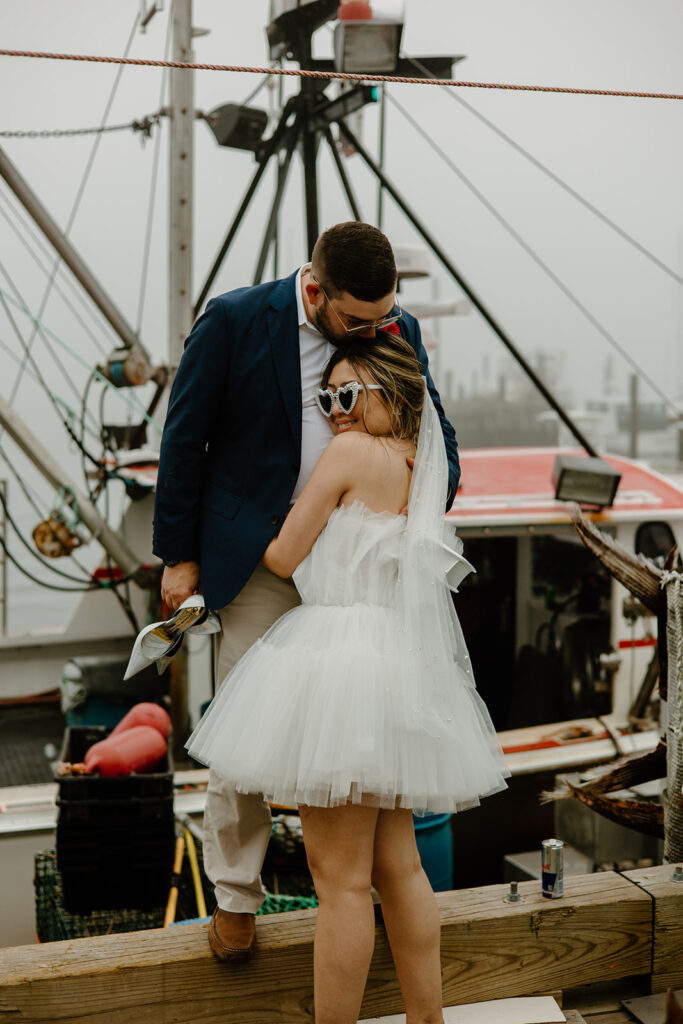 Bride and groom posing on a dock in Portland, Maine.
