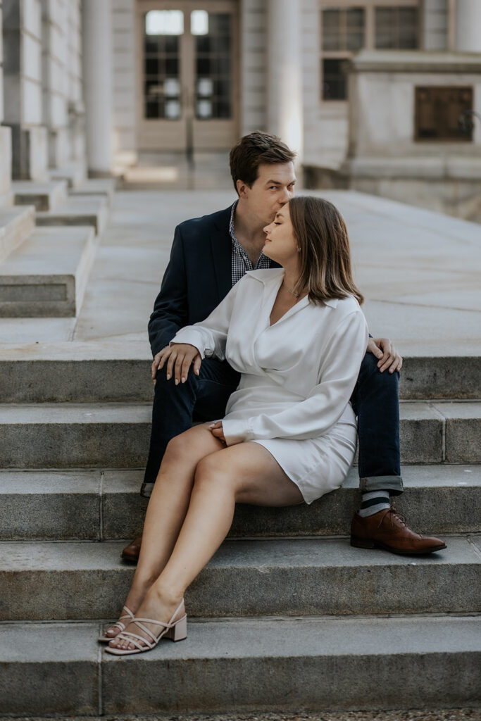 Couple sitting on the steps of Portland Maine City Hall.