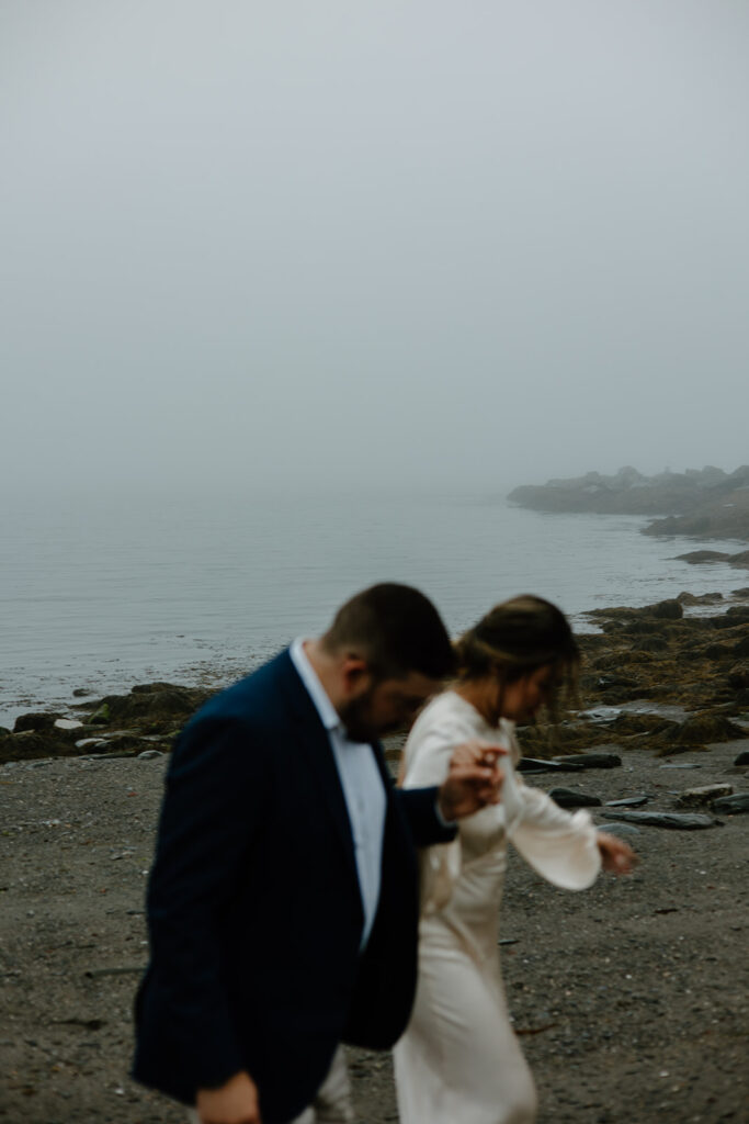 Couple walking on the beach of Two Lights State Park in Maine.