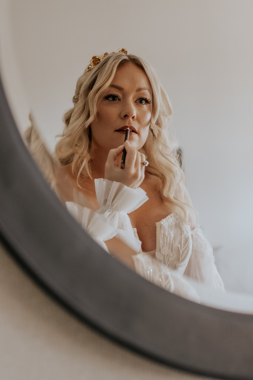 Maine bride getting ready putting on lip liner.