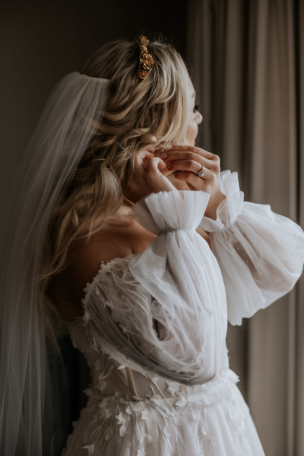 Bride getting ready putting on earrings.