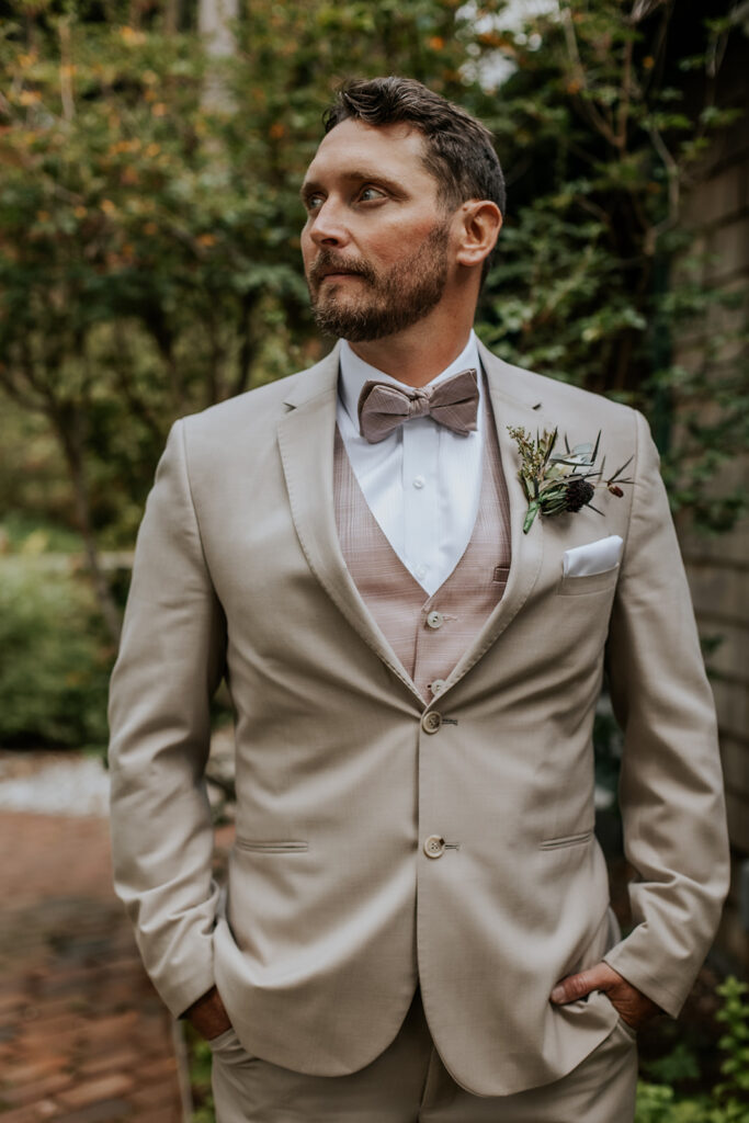 Groom portrait with tan and dusty mauve attire.