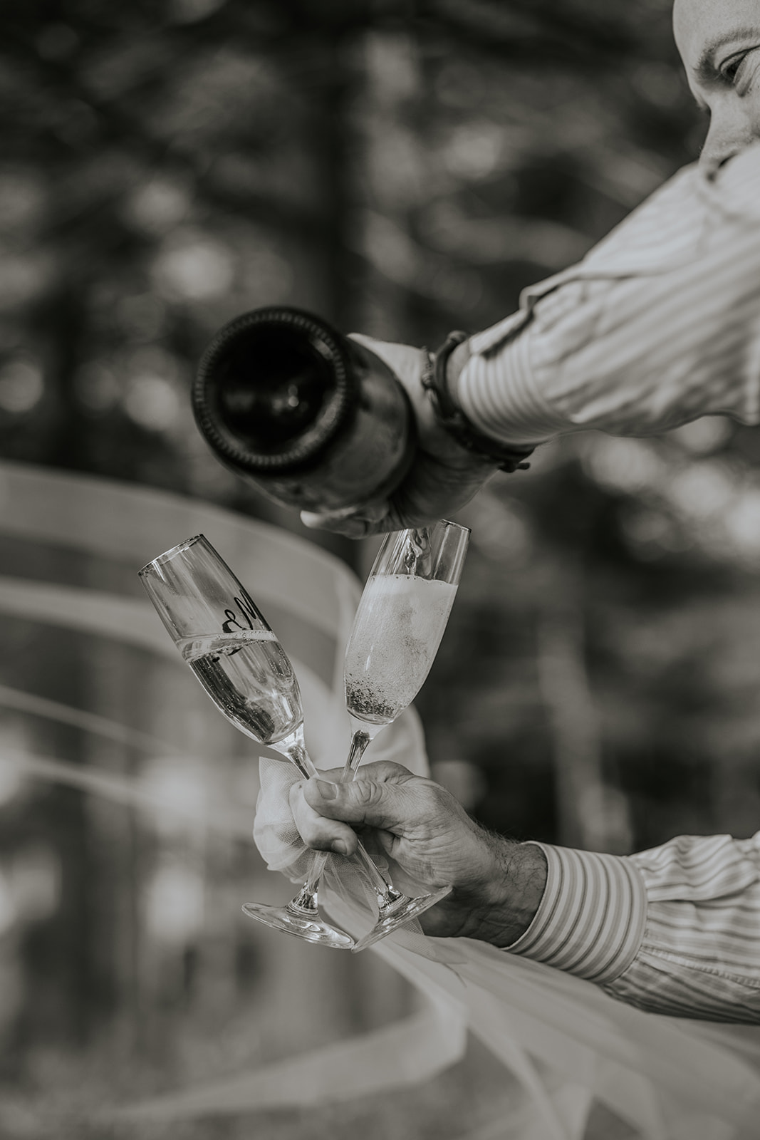 Man pouring champagne into two glasses.
