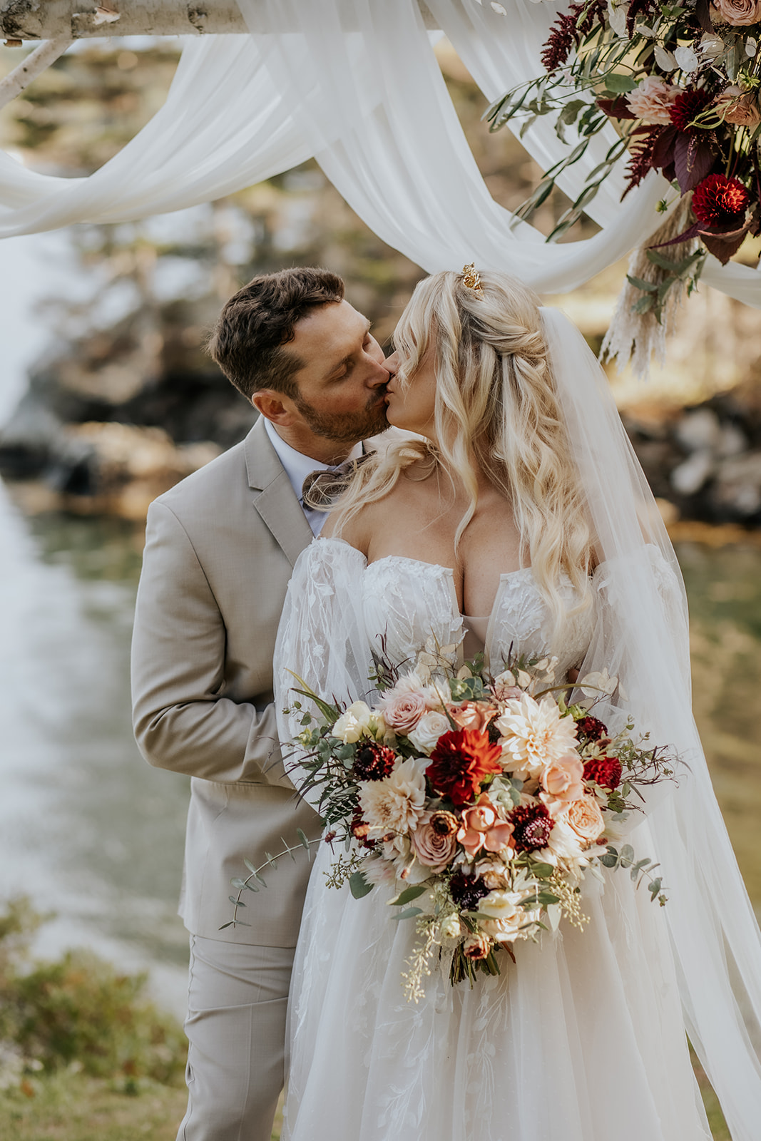 Bride and groom portrait against a wood birch arbor backdrop.
