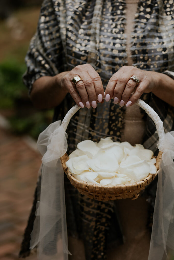 Bride's grandma holding a basket of white petals as the flower girl.
