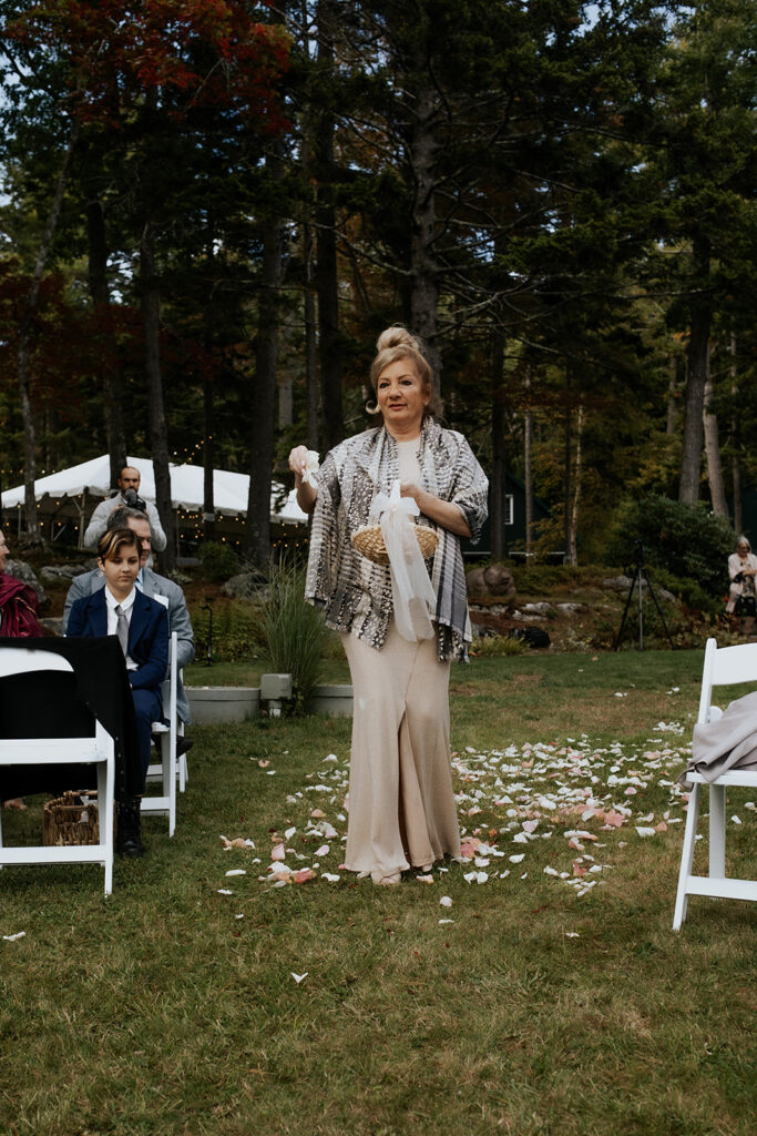 Bride's grandma walking down the aisle spreading flower petals.