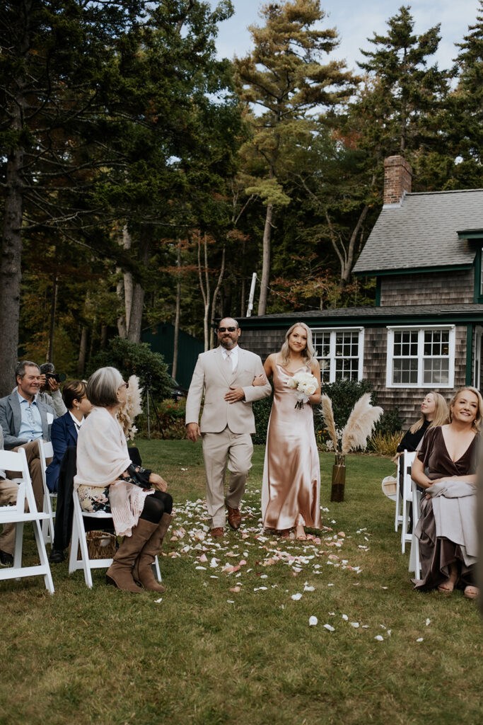 Bridesmaid and groomsmen walking down the aisle at a private backyard wedding in Maine.