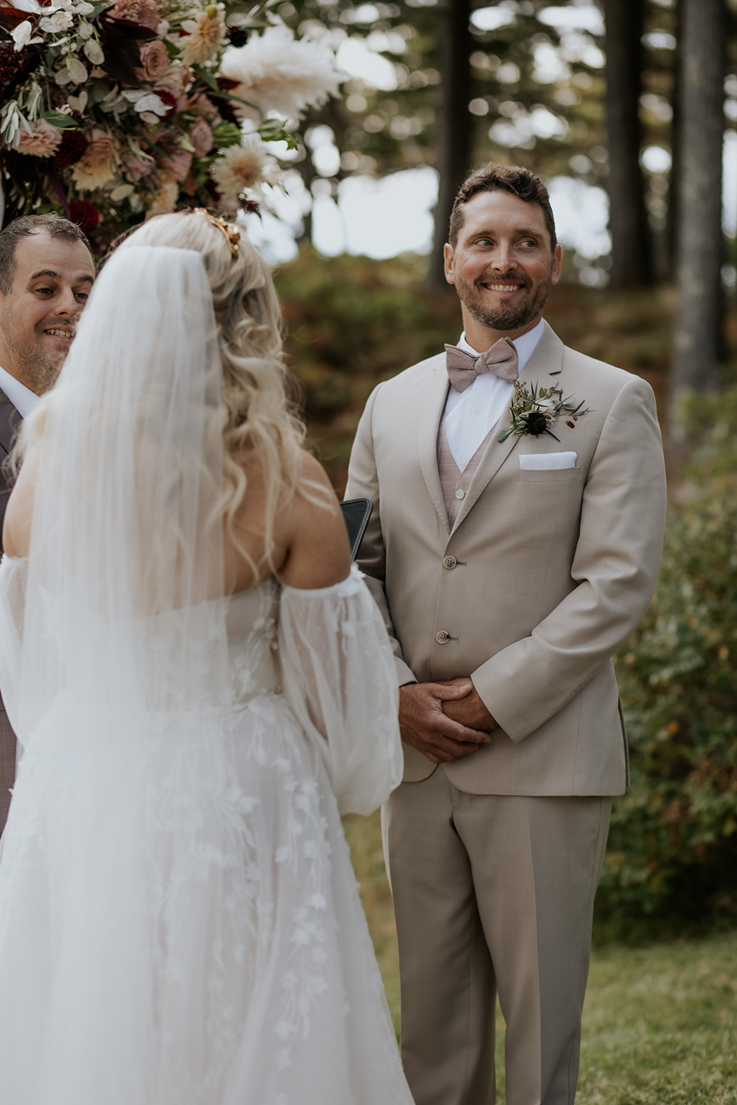 Groom smiling during outdoor wedding ceremony.
