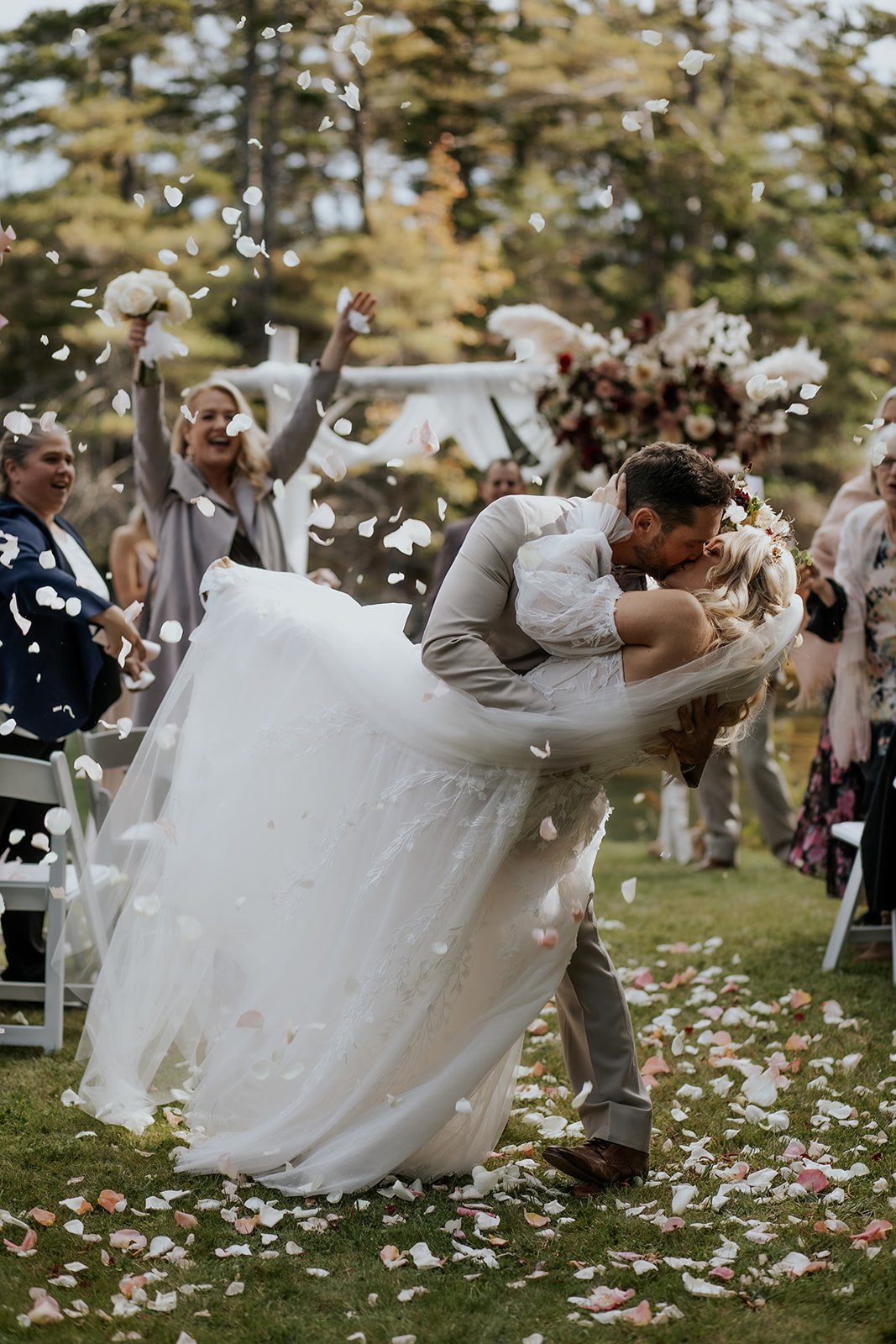Bride and groom recessional kiss at outdoor wedding in Maine.