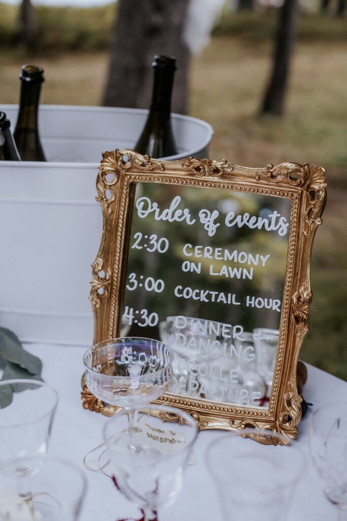 Order of events gold mirror wedding sign.