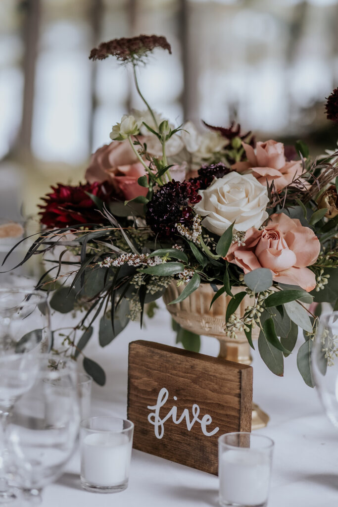 Wooden wedding table number and centerpiece bouquet.