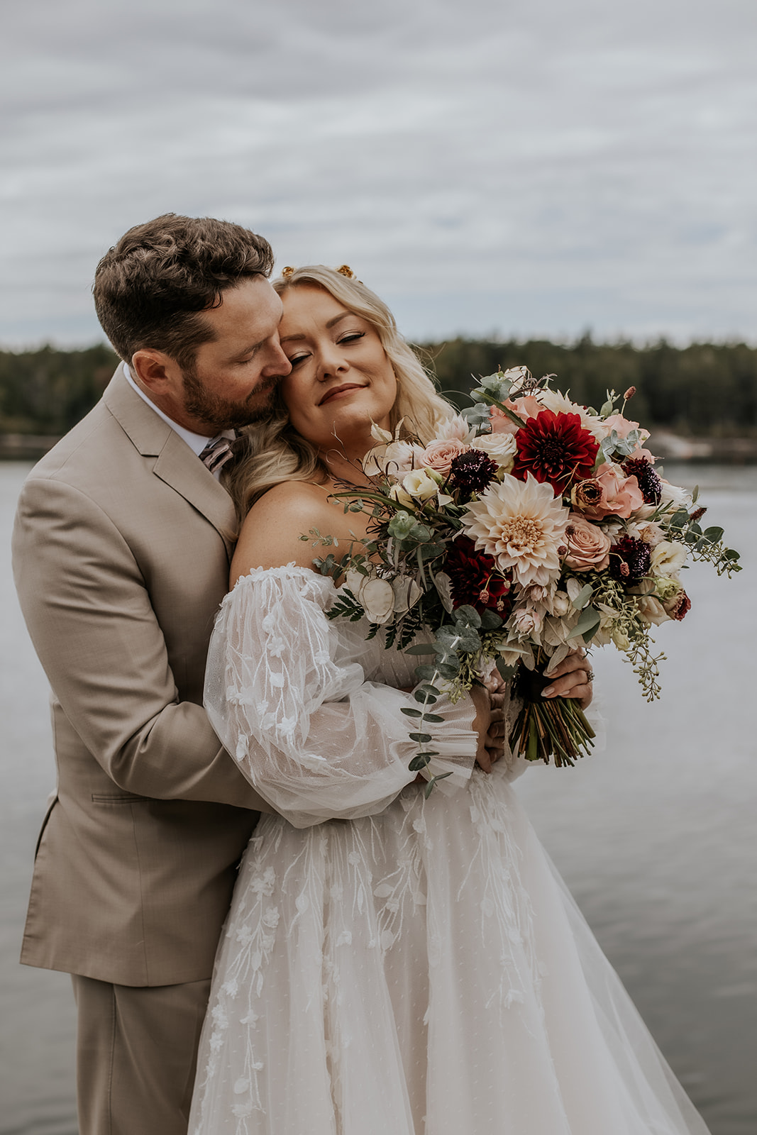 Fall wedding in Bath, Maine bride and groom portrait by the water.