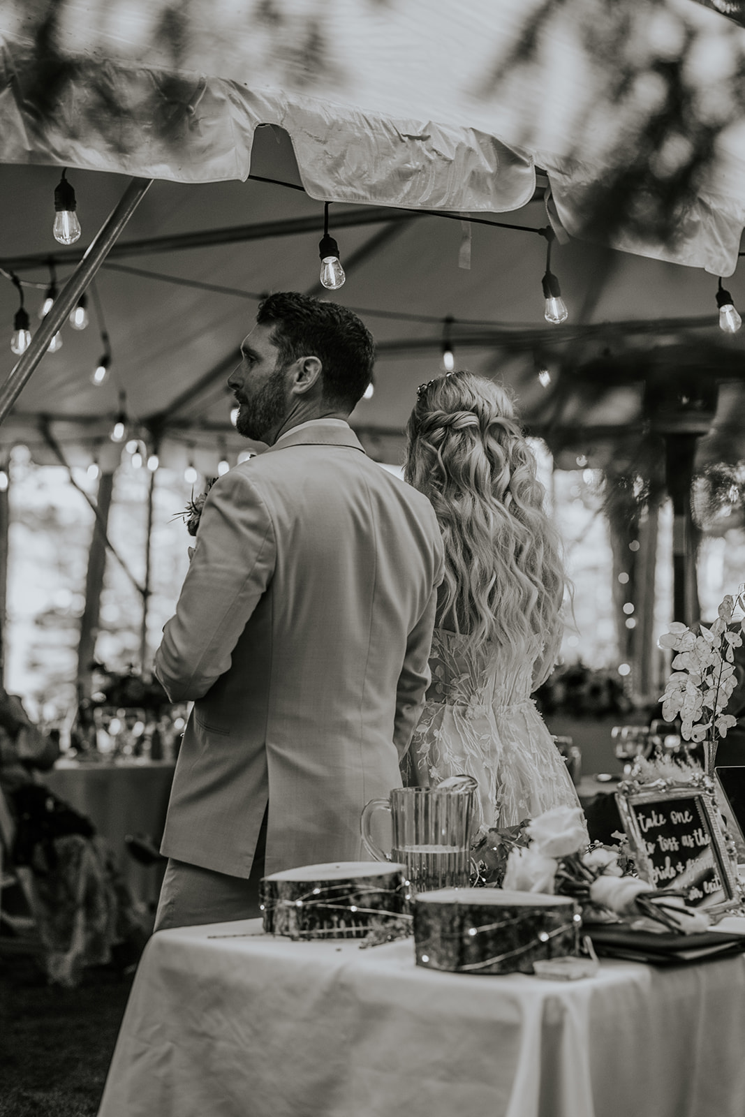 Bride and groom standing speaking to their guests.