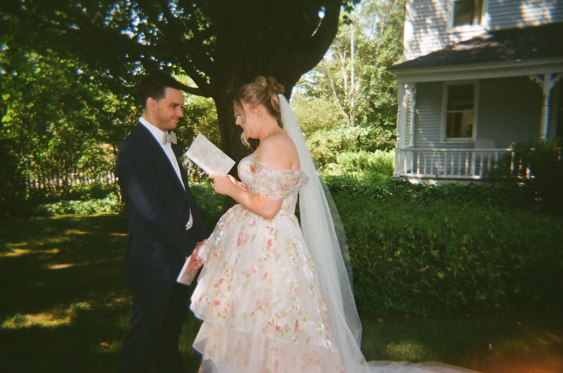 A quiet moment under the trees as the couple exchanges vows, sunlight filtering through the branches.