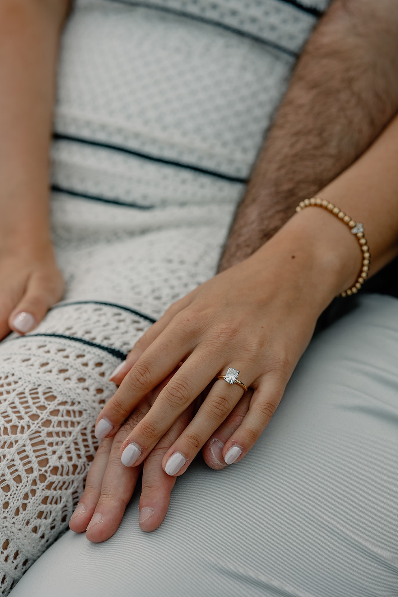 Close-up of engagement ring resting on the bride’s hand as she holds her partner, captured at one of Maine’s intimate Engagement Photo Locations.