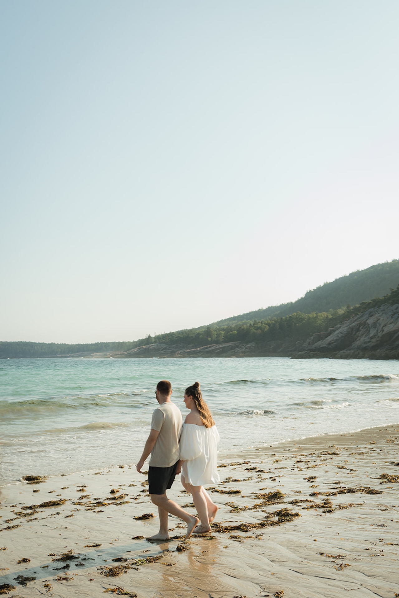 Couple walking along the beach at Acadia National Park during their Acadia Engagement photo shoot
