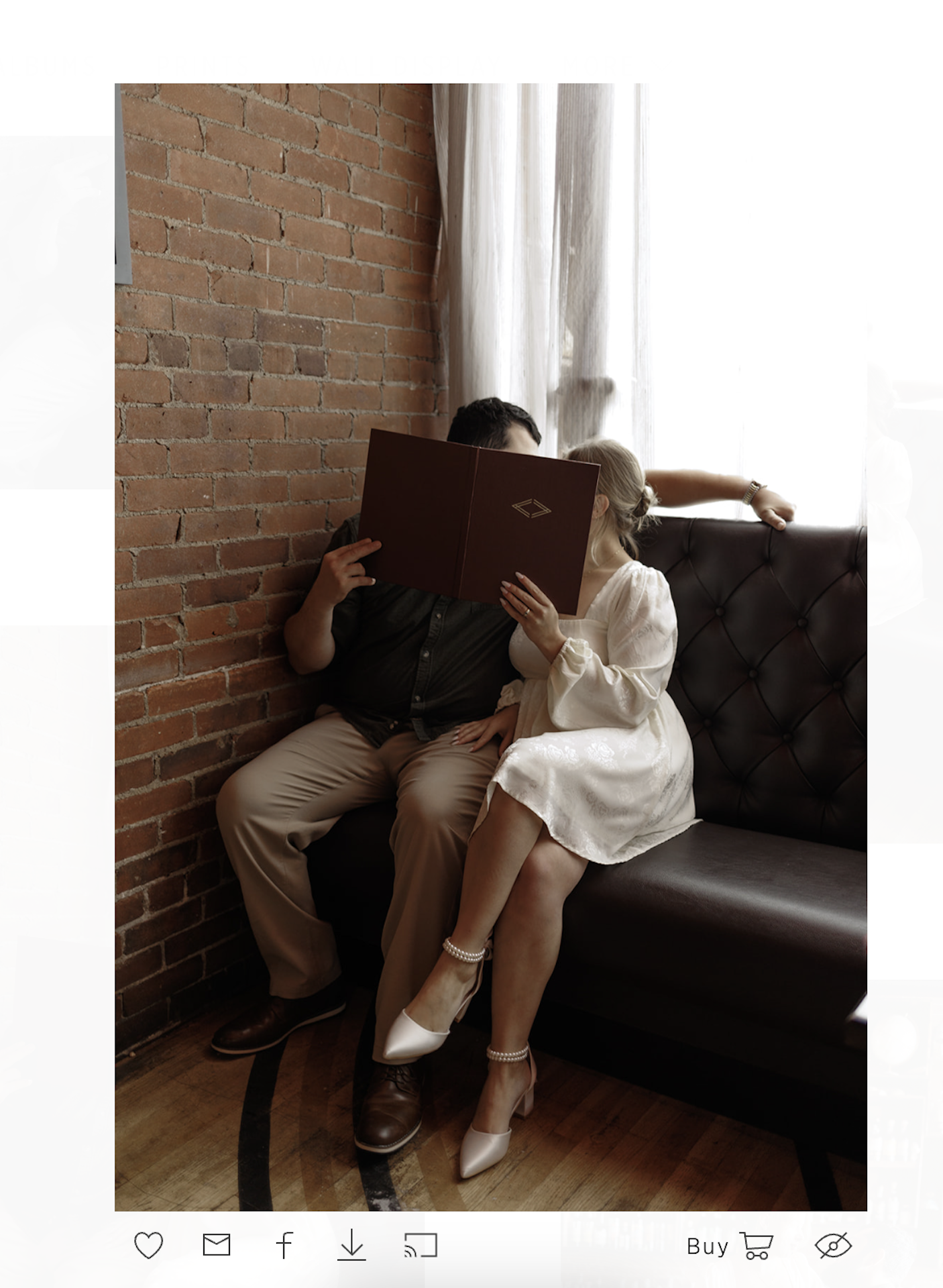 A photo of a couple holding up a menu to cover their faces during their engagement shoot. This is a screenshot from a gallery to showcase how photos show up on Pic Time, the Best Online Gallery for Photographers