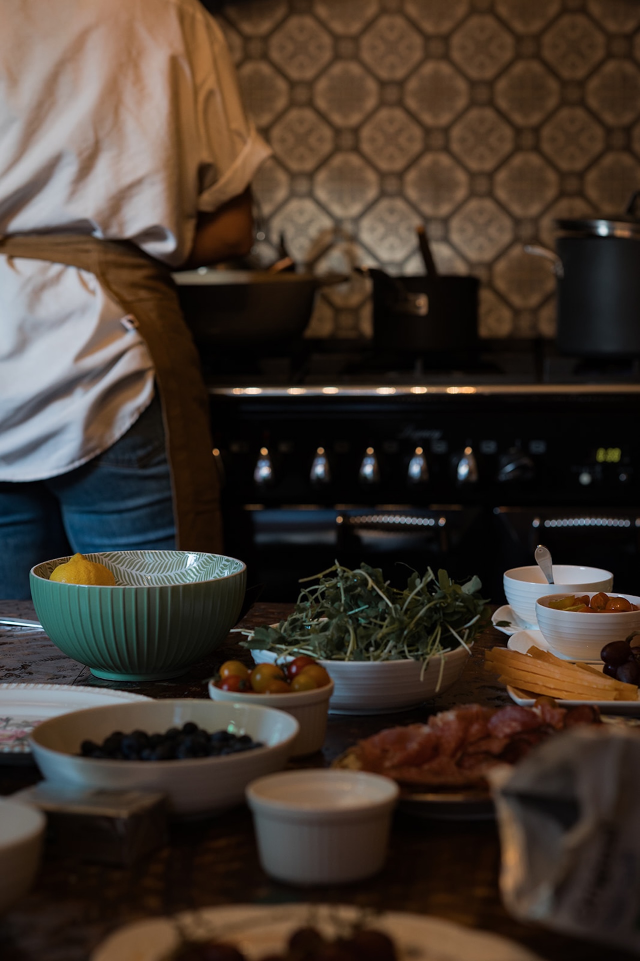 A behind-the-scenes look at dinner being prepared in the kitchen with fresh ingredients on the counter.
