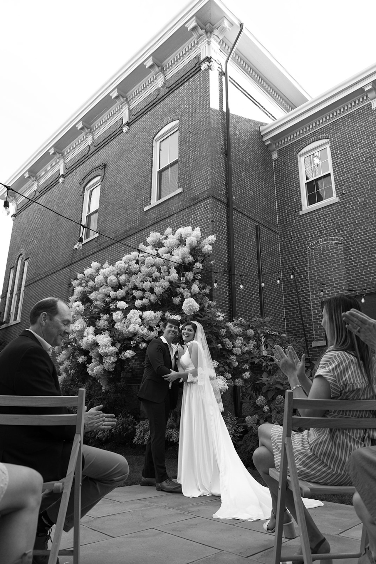 The newly weds hugging and smiling at the altar while looking at the camera during their historic wedding venue ceremony.
