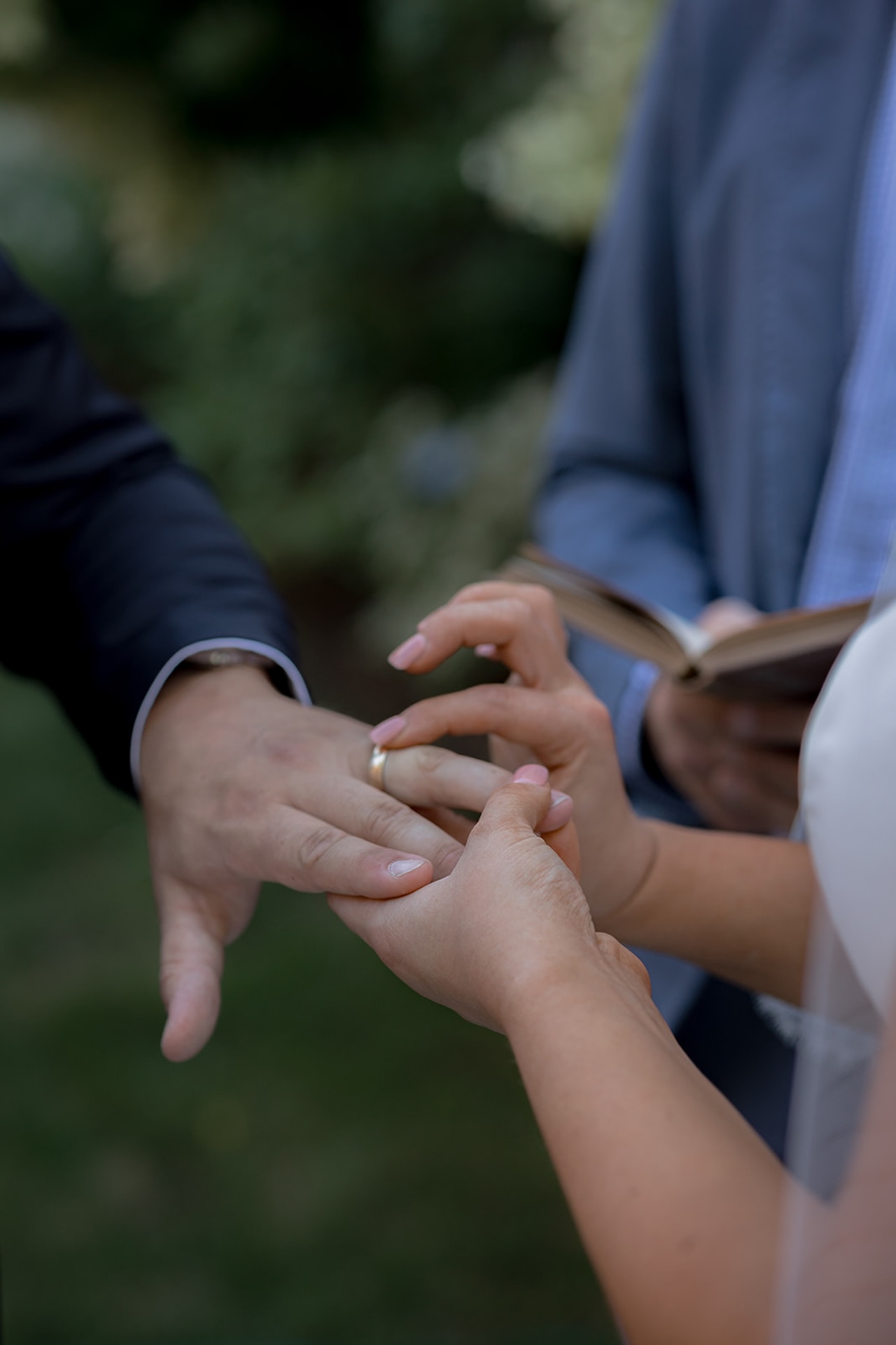 Bride slipping the ring onto the groom’s finger during the ceremony.