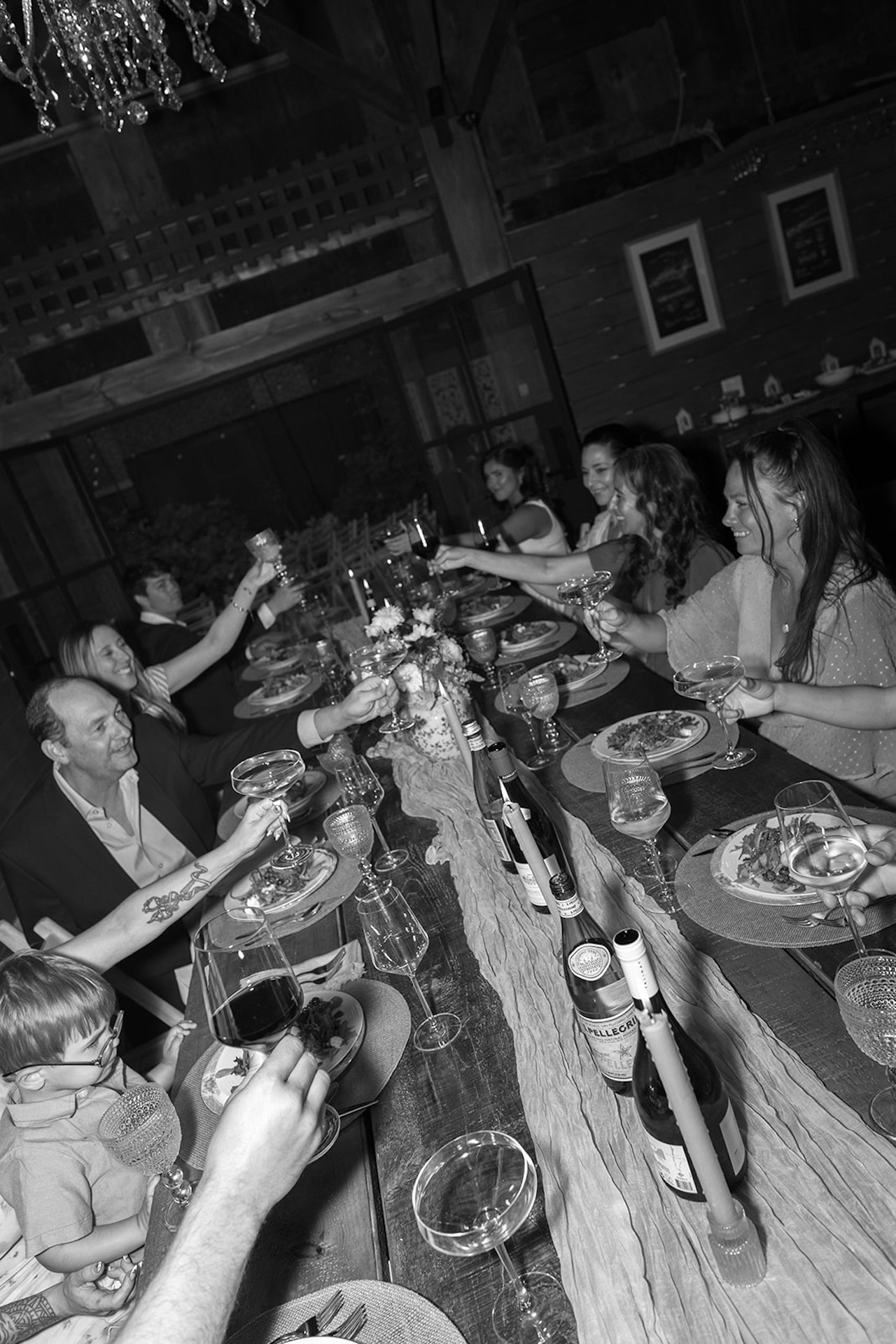 Wedding guests laughing and raising a toast to the bride and groom during their Maine Micro wedding reception