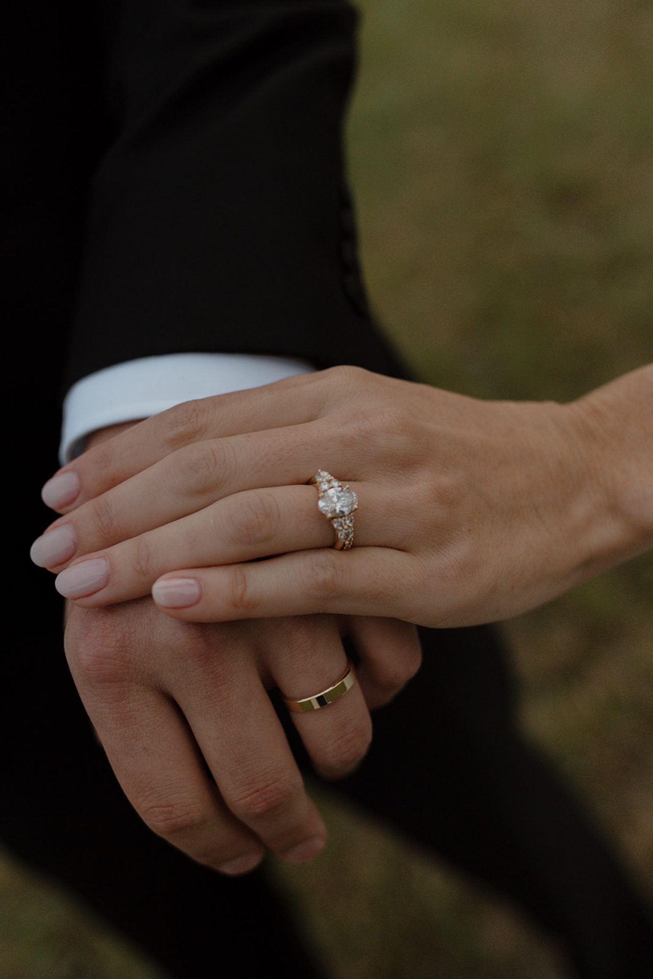 Close-up of joined hands showing their rings, celebrating their Wedding in Maine.