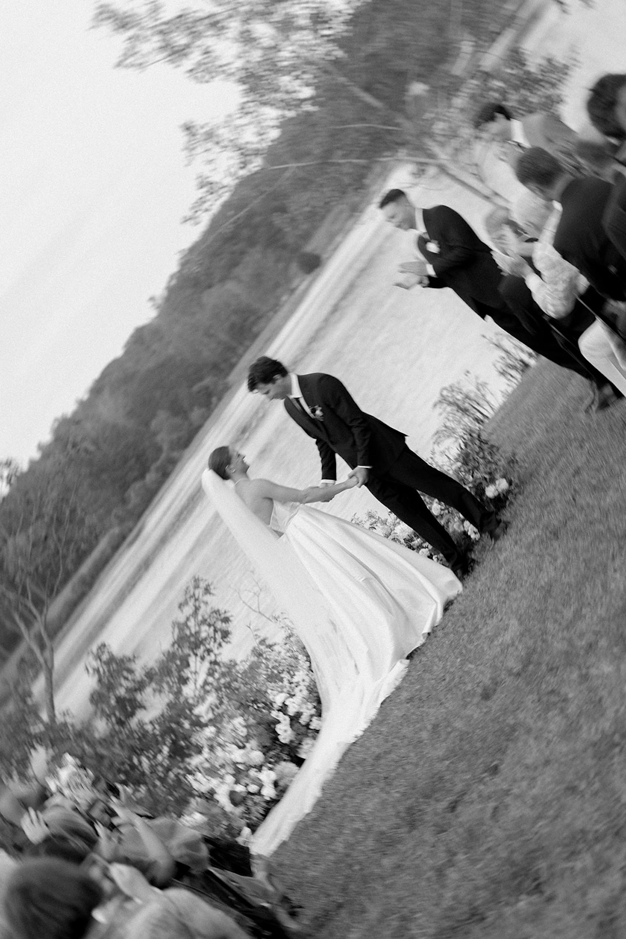 Blurry artistic photo of the couple holding hands during their ceremony by the lake.