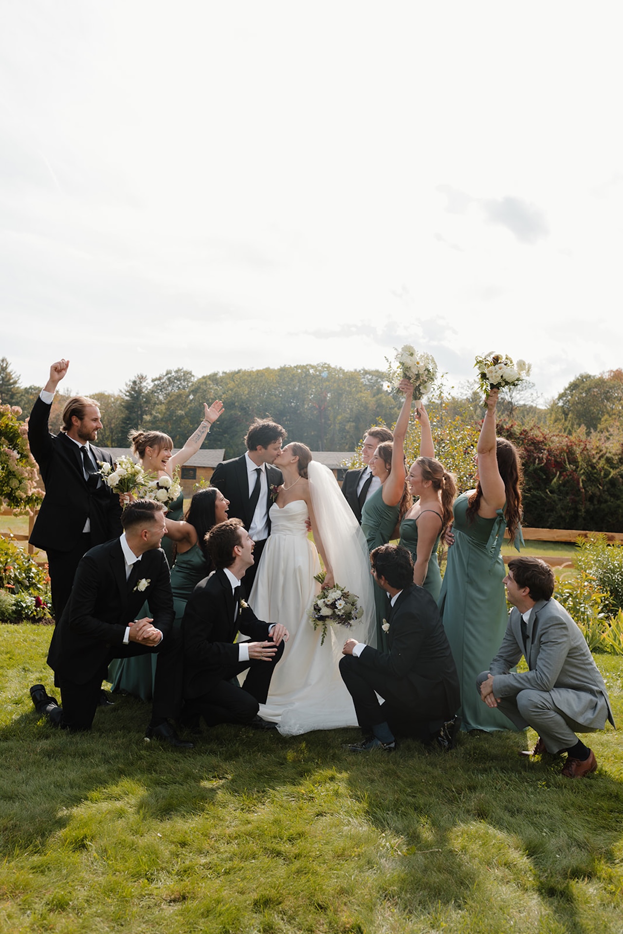 Wedding party walks across the field toward the ceremony at a lakeside Wedding in Maine.