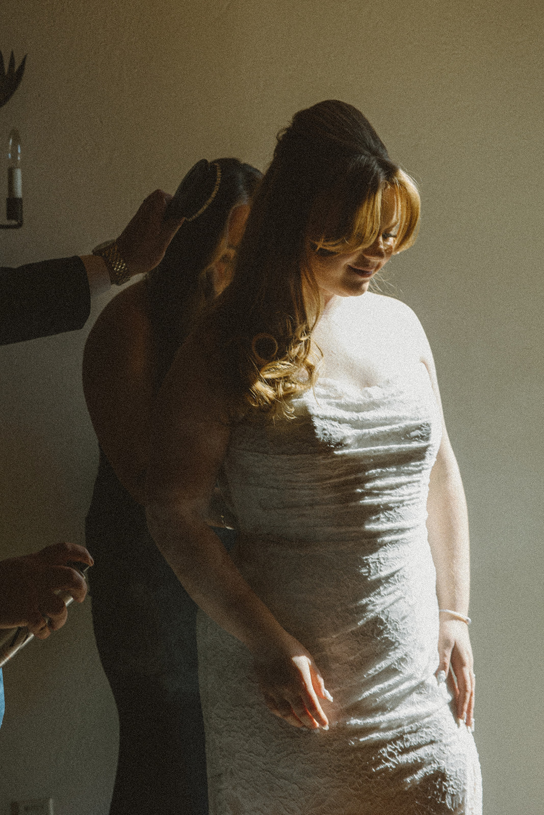 Bride having her hair finished in soft window light during a Destination Wedding in Maine, wearing a lace strapless gown with a relaxed, intimate getting ready atmosphere