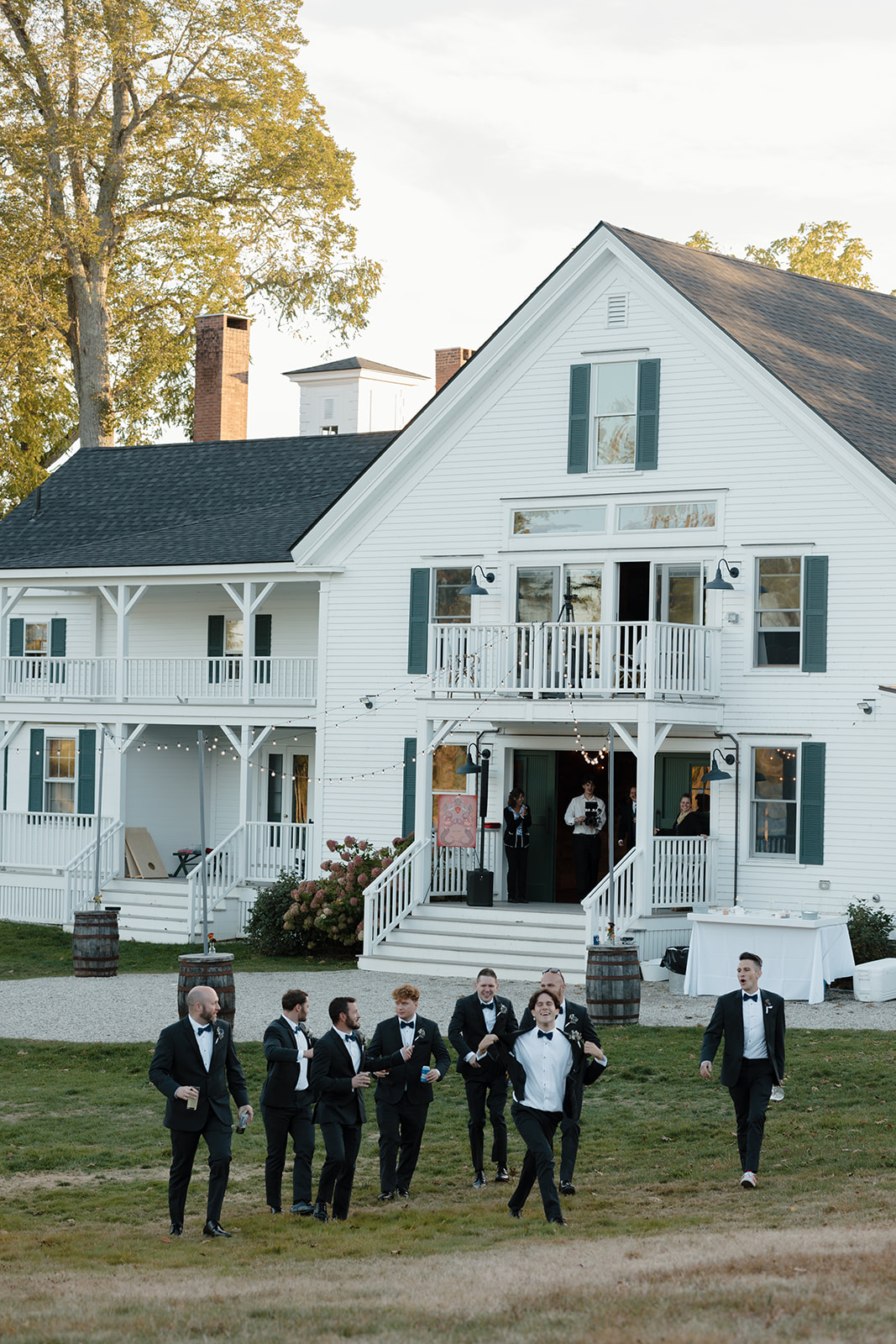 The groom and groomsmen walking away from The Inn 1774 Wedding venue to head towards the reception wedding tent.
