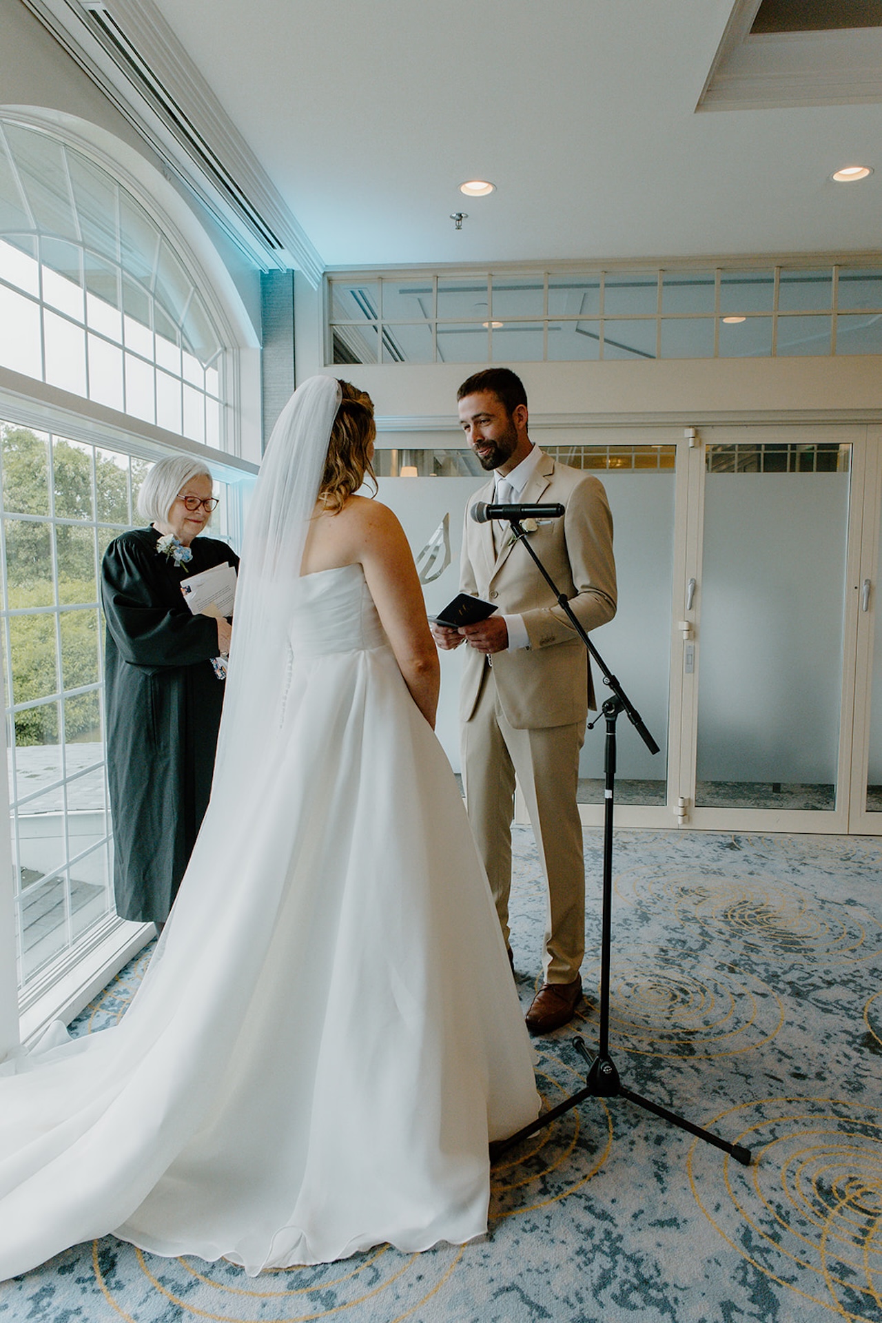 Bride and groom exchanging vows during an indoor ceremony overlooking the ocean at Stage Neck Inn.