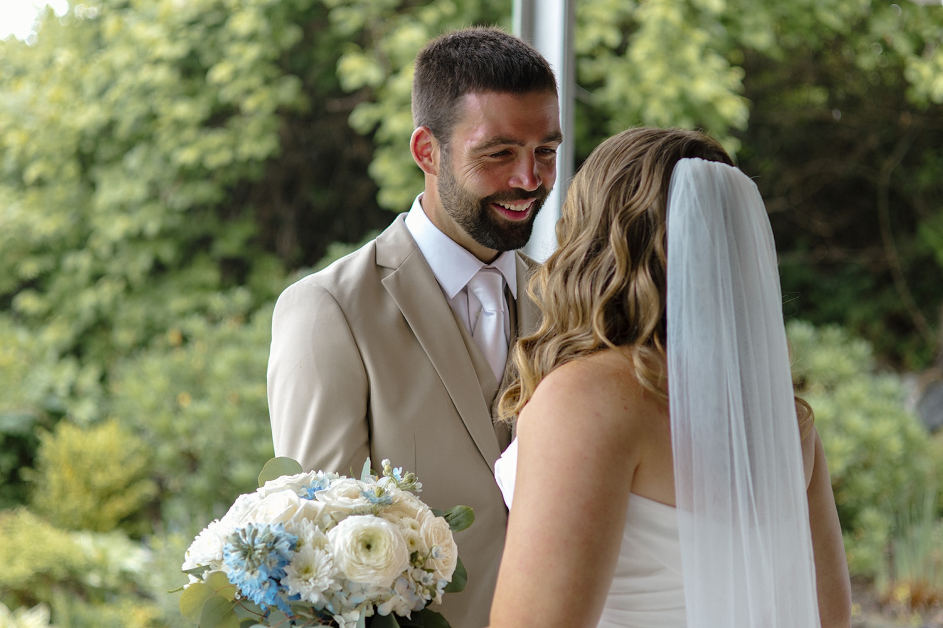 Newlyweds embracing in front of oceanview windows inside Stage Neck Inn wedding venue.