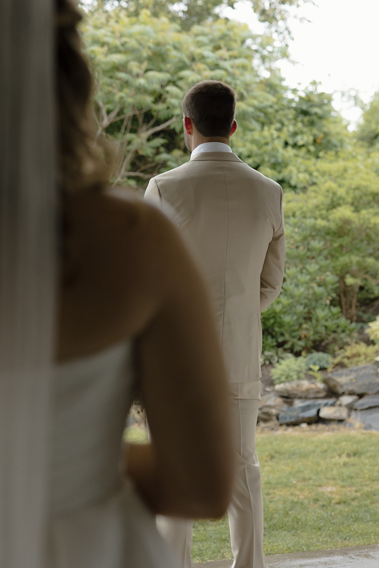 Bride walking up behind groom during their first look outside at Stage Neck Inn.