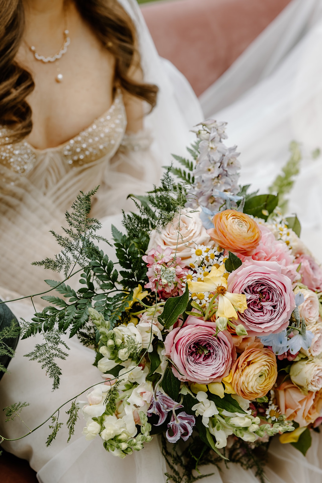 Bridal portraits with the brides dress details while she holds a bright floral bouquet, perfect inspiration for colorful weddings.