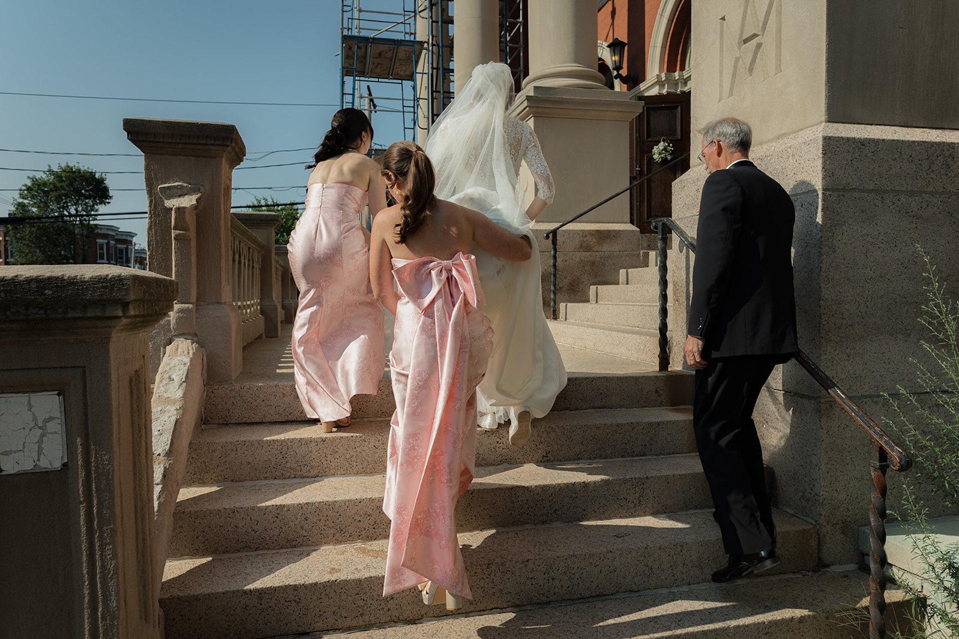 Bridesmaids in pink holding the brides train. Inspiration for colorful weddings.
