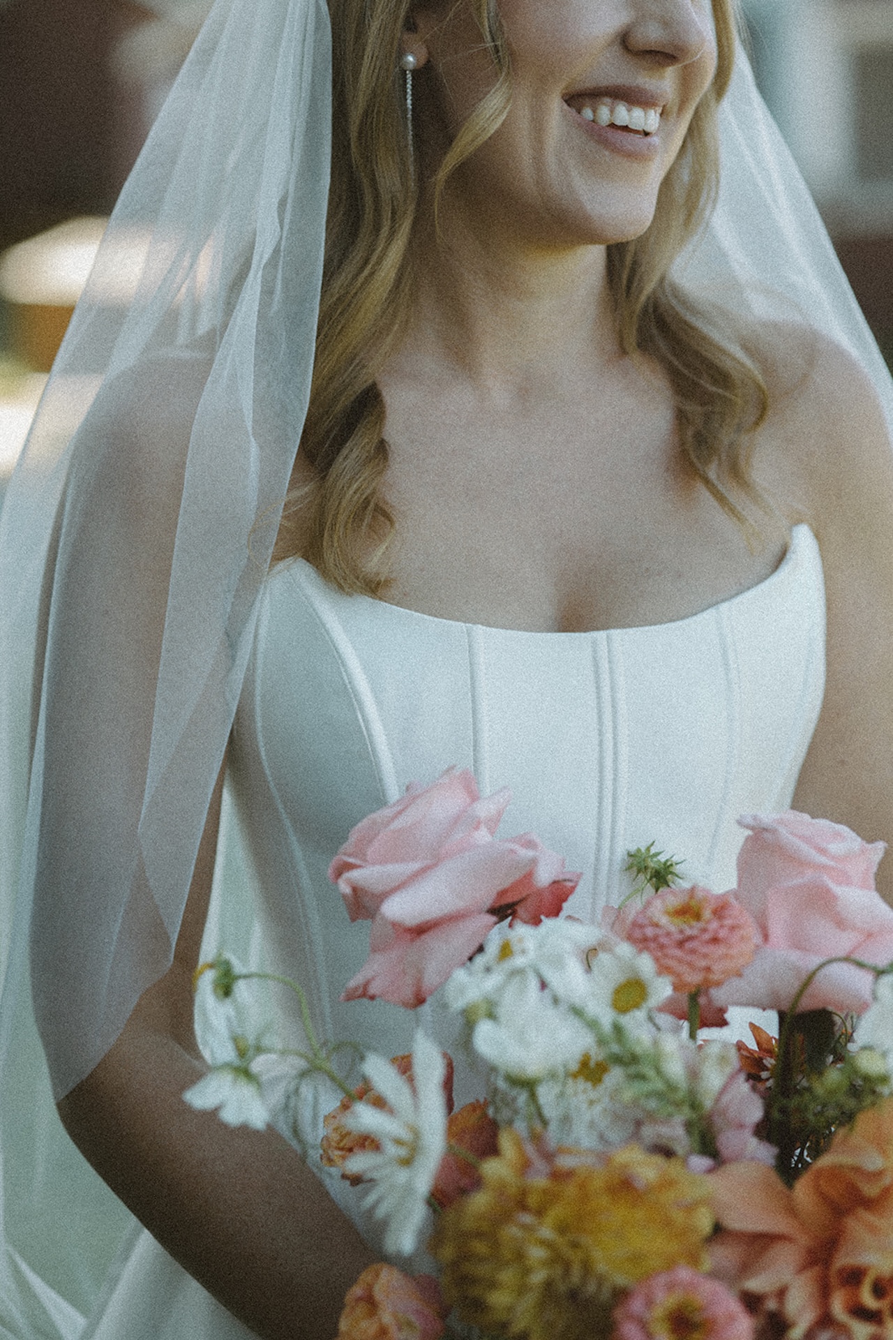 Bridal portraits with the brides dress details while she holds a bright floral bouquet, perfect inspiration for colorful weddings.