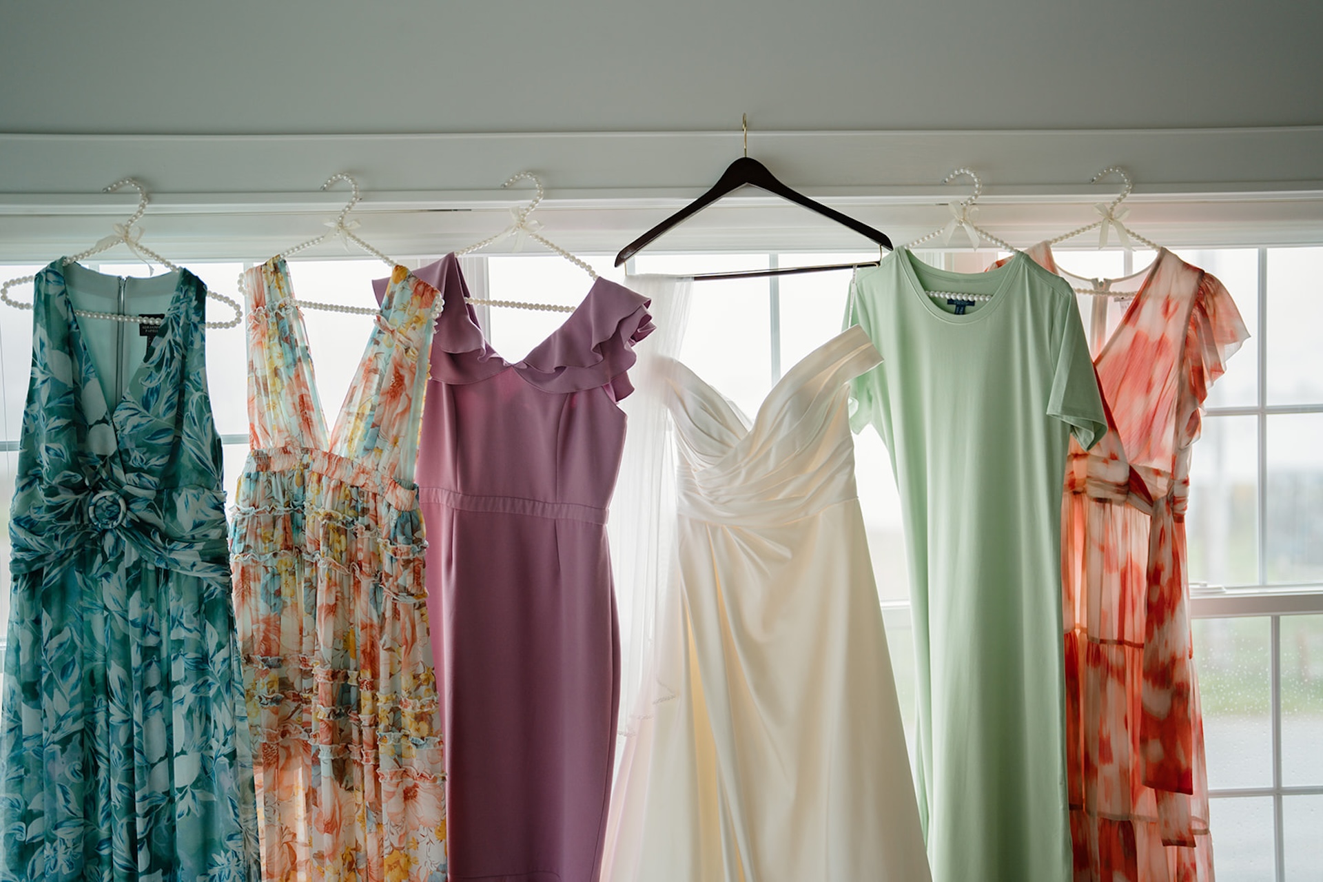 Colorful bridesmaids dresses handing along with the brides dress for colorful wedding inspiration.