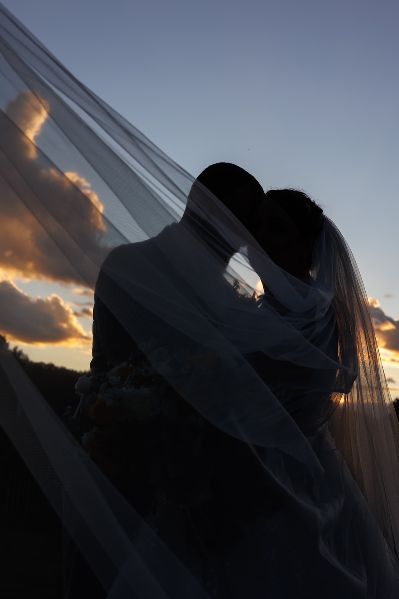 Silhouette of bride and groom during sunset portraits at a colorful weddings celebration
