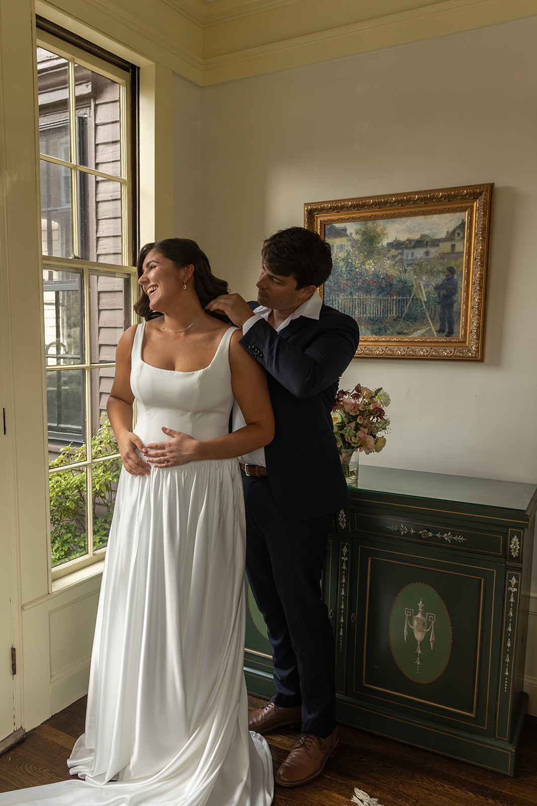 Bride helped with dress during traditional wedding preparation