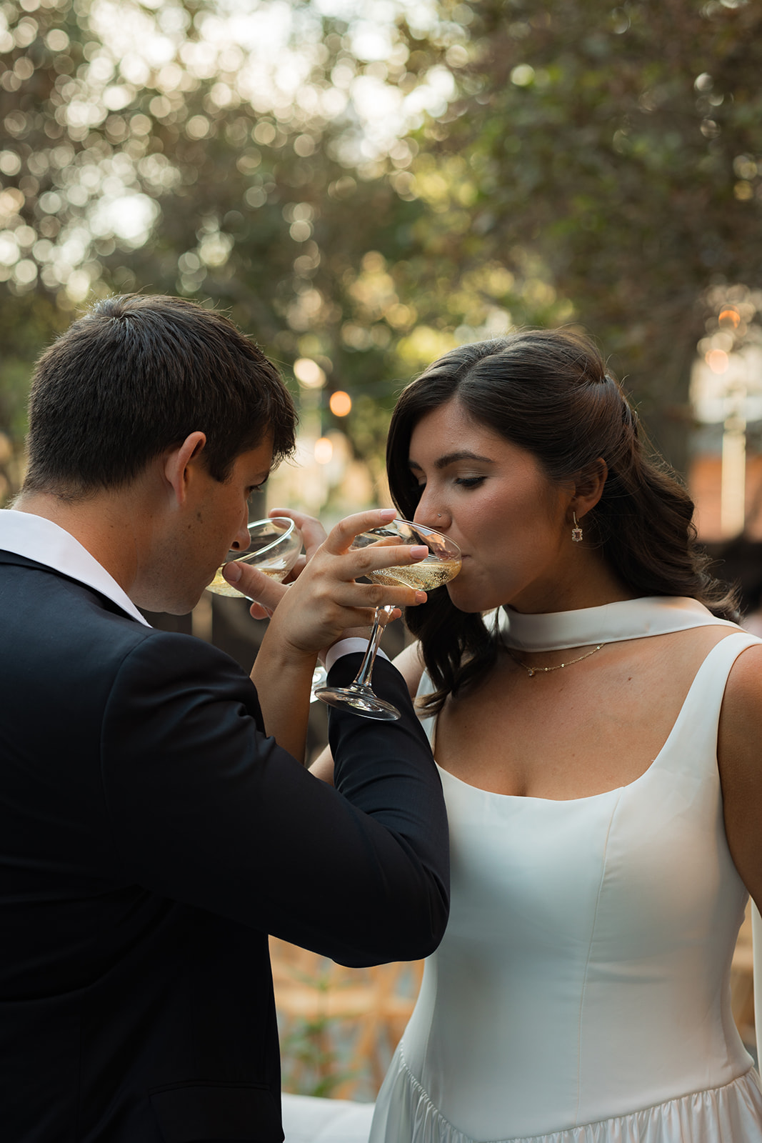 Bride and groom share a drink at intimate wedding