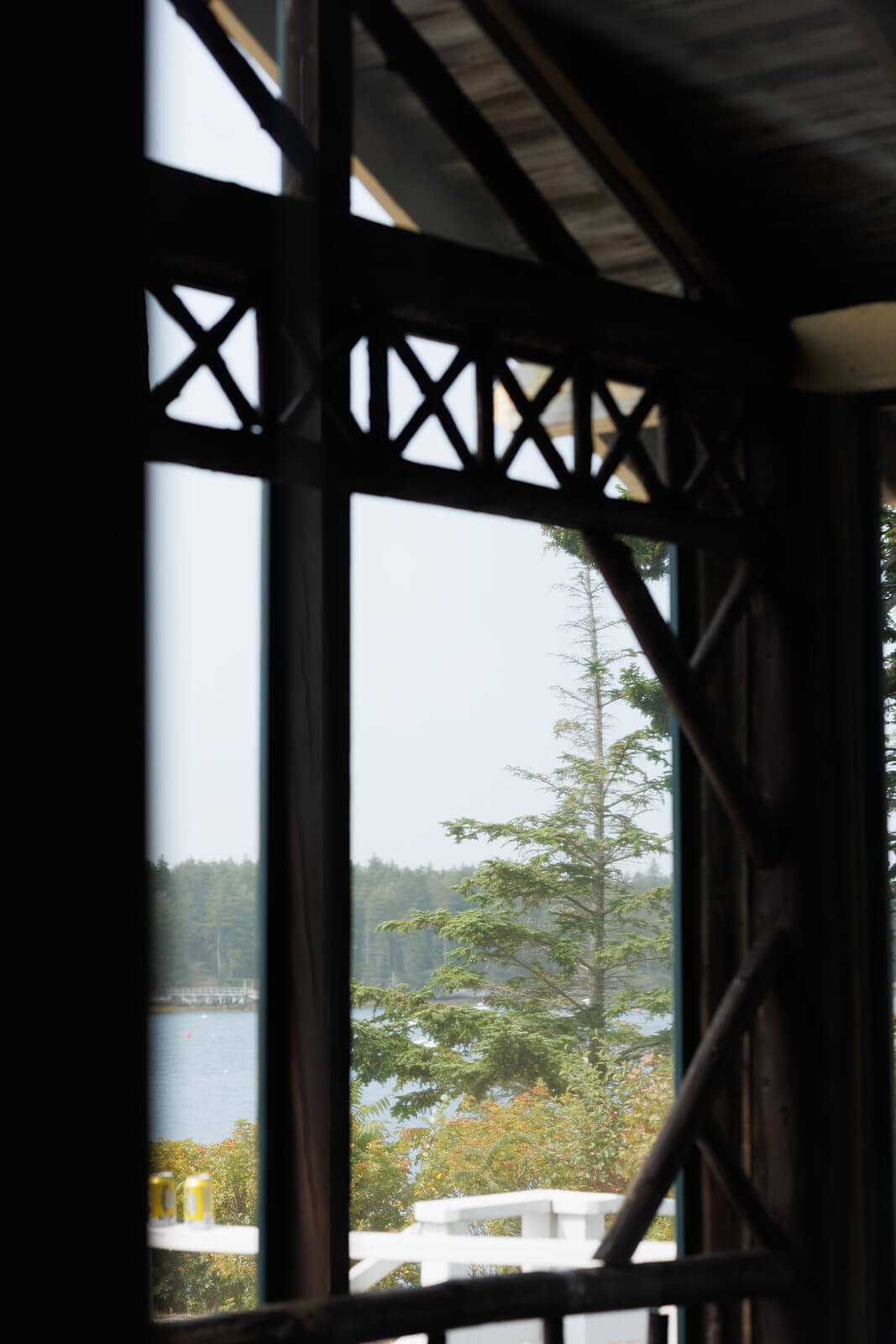 Harbor view through the wooden windows of a coastal Maine wedding venue overlooking the water.